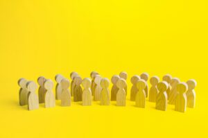 A large group of figurines of people on a yellow background.